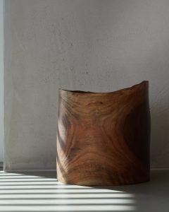 Handgedrechselte Holzschale aus massivem Nussbaum mit charaktervoller Maserung, inszeniert im natürlichen Licht vor gespachtelter Kalkputzwand – hochwertiges Wohnaccessoire im minimalistischen Design